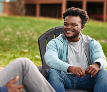 Chris, a real person with narcolepsy with cataplexy, sitting with friends outdoors